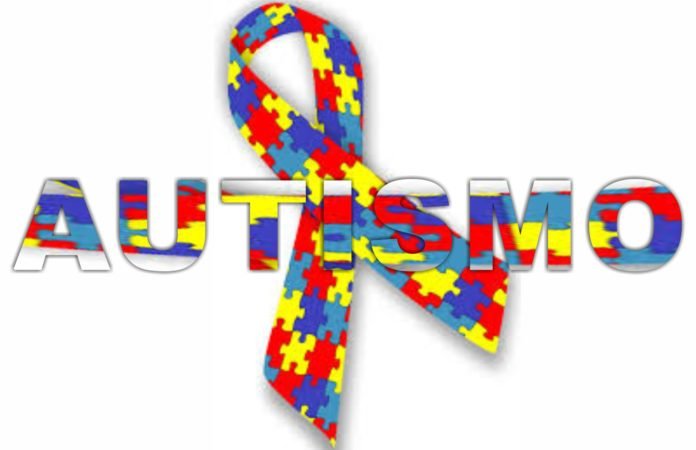 Descrição da imagem #ParaCegoVer: A imagem está no formato retangular, na horizontal. Nela está escrito a palavra Autismo, com letras estampadas por peças coloridas de quebra-cabeça. O laço, símbolo do autismo, está sobreposto à palavra principal. Fim da descrição.