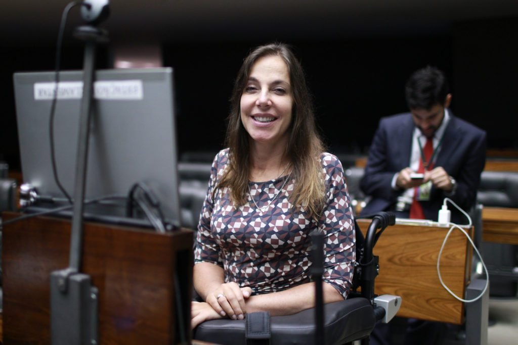 Descrição da imagem #PraCegoVer: A imagem está no formato retangular, na horizontal. Nela, a deputada federal Mara Gabrilli está na Câmara dos Deputados, em Brasília. Ela sorri. Fim da descrição.