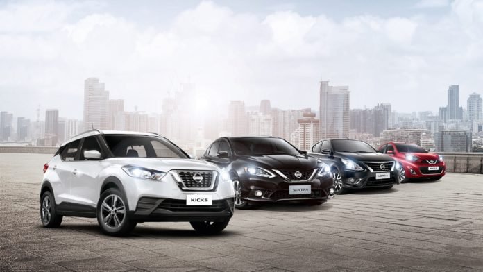 Descrição da imagem #PraCegoVer: Imagem em formato retangular, na horizontal. Nela estão quatro modelos de automóveis da marca Nissan. Todos eles podem ser vendidos com isenções de impostos para pessoas com deficiência. Os modelos estão enfileirados e ao fundo é possível ver uma paisagem urbana, com prédios. Fim da descrição.