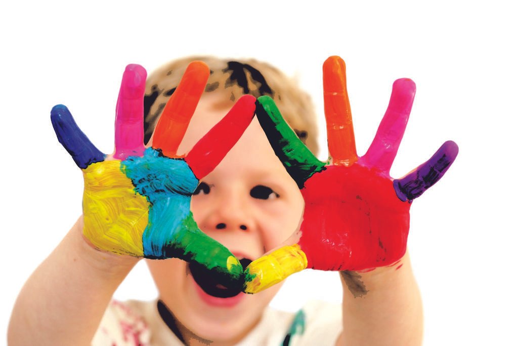 Descrição da imagem #PraCegoVer: A imagem tem fundo branco e nela está um menino com os braços esticados e as mãos pintadas nas cores amarelo, azul, verde, pink, laranja e vermelho. Fim da descrição.