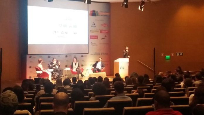 Descrição da imagem #PraCegoVer: Imagem no formato retangular, na horizontal. Nela vemos o palco do fórum da diversidade. No palco estão quatro pessoas, sendo uma delas, um intérprete de Libras. Fim da descrição.