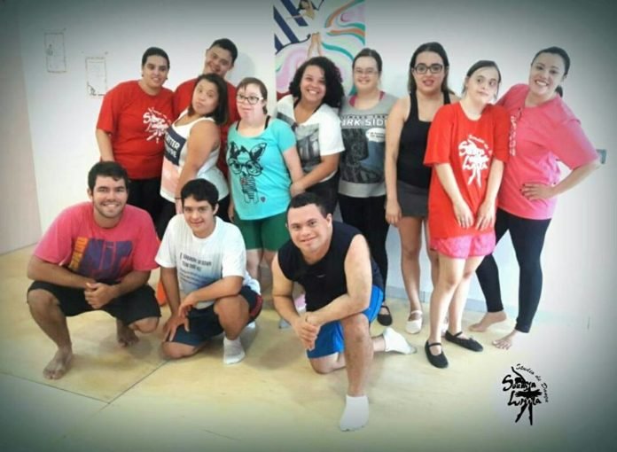 Descrição da imagem #PraCegoVer: A imagem está no formato retangular, na horizontal. Nela, estão os dançarinos com deficiência e professores de dança do Studio Soraia Lima. Eles estão sorrindo. Fim da descrição.