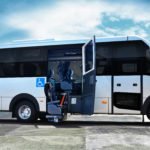 Descrição da imagem #PraCegoVer: A imagem está no formato retangular, na horizontal. Nela está o micro-ônibus adaptado da IVECO, A imagem mostra a lateral do ônibus e é possível ver que ele está com a porta aberta. Com isso, podemos ver também o elevador de transferência dos passageiros com deficiência física para o interior do micro-ônibus. Fim da descrição.