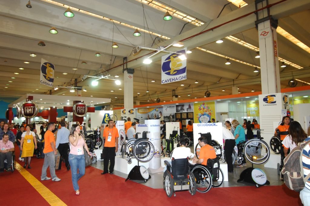 Descrição da imagem #PraCegoVer: A imagem está no formato retangular, na horizontal. Nela é possível ver um dos corredores do evento, em uma edição anterior. É possível ver uma grande movimentação de pessoas e alguns produtos expostos. Fim da descrição.