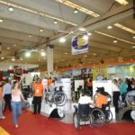 Descrição da imagem #PraCegoVer: A imagem está no formato retangular, na horizontal. Nela é possível ver um dos corredores do evento, em uma edição anterior. É possível ver uma grande movimentação de pessoas e alguns produtos expostos. Fim da descrição.