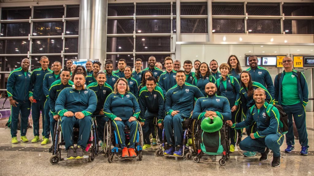 Descrição da imagem #PraCegoVer: Imagem no formato retangular, na horizontal. Os atletas da delegação brasileira de atletismo durante o embarque para Londres. Eles estão todos juntos e uniformizados, com um agasalho verde. Fim da descrição.