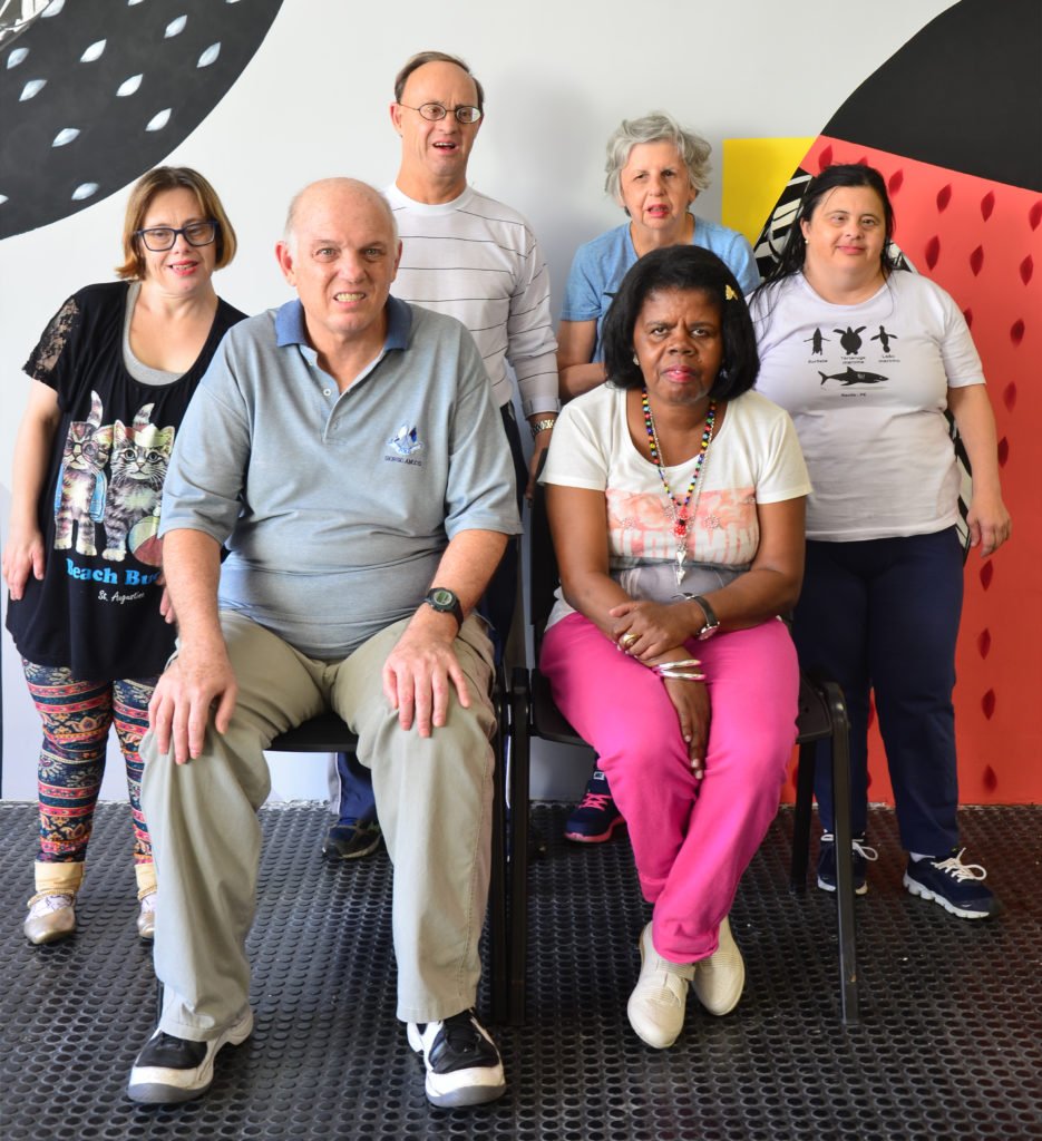 Descrição da imagem #PraCegoVer: Alguns dos integrantes do grupo de Envelhecimento da APAE DE SÃO PAULO. São seis pessoas. sendo quatro mulheres e dois homens. Quatro deles estão em pé e dois estão sentados. Fim da descrição.