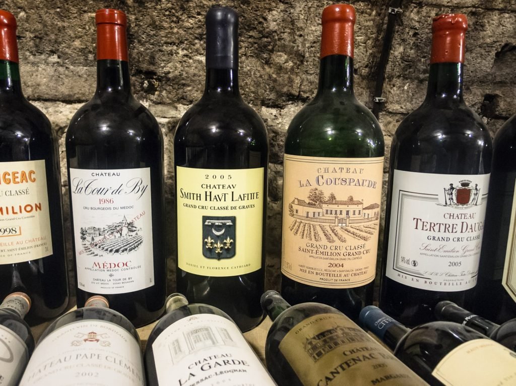 Descrição da imagem #PraCegoVer: Imagem no formato retangular, na horizontal. Dez garrafas de vinho estão sobre uma mesa. Cinco delas estão deitadas e outras cinco estão em pé. Fim da descrição.