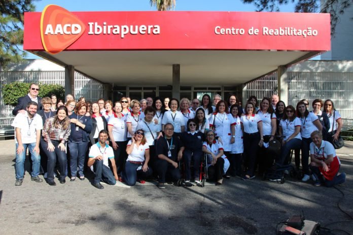 Descrição da imagem #PraCegoVer: Imagem no formato retangular, na horizontal. Um grupo de voluntários da AACD posa para foto na frente da unidade Ibirapuera. Fim da descrição.