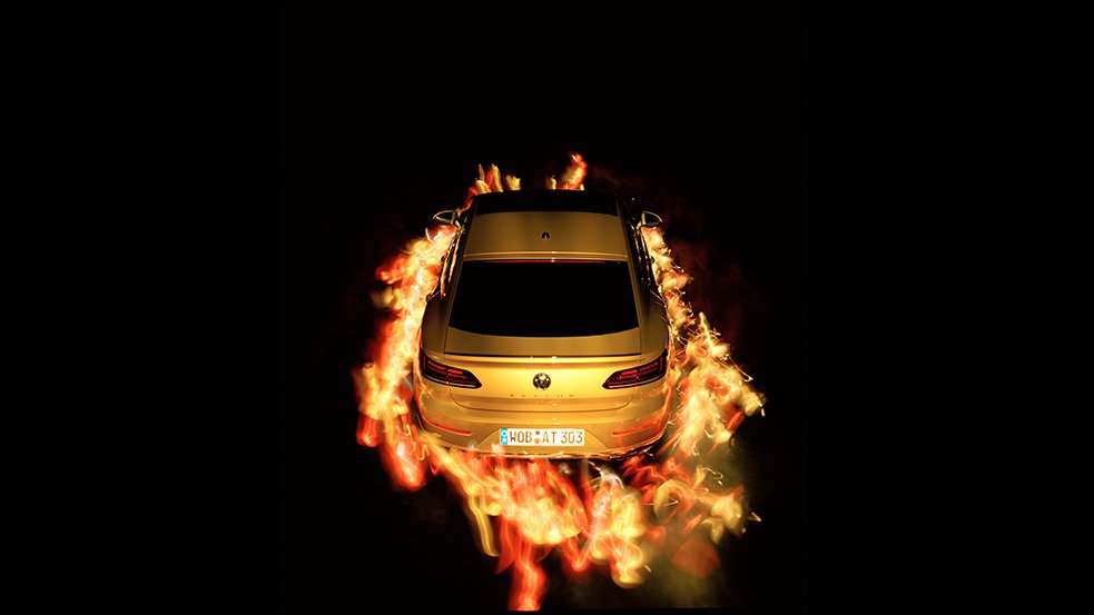Descrição da imagem #PraCegoVer: Imagem no formato retangular, na horizontal. A imagem tem fundo preto. O carro está no centro da imagem. Ele tem à sua volta uma espécie de roda de fogo, que na verdade, é um jogo de luzes da técnica utilizada pelo fotógrafo cego. Fim da descrição.