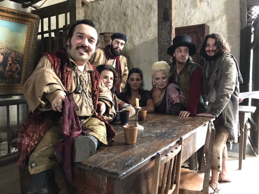 Descrição da imagem #pracegover: O ator Gigante Leo entre os atores de seu núcleo da novela Novo Mundo. Fim da descrição.