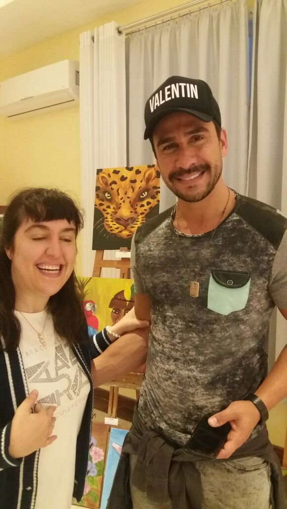 Descrição da imagem #PraCegoVer: A imagem está no formato retangular, na vertical. Glenda está ao lado de seu amigo Julio Rocha. Eles estão sorrindo. Fim da descrição.