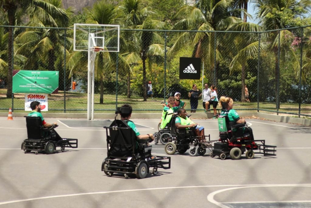 Descrição da imagem #PraCegoVer: Imagem no formato retangular, na horizontal. Treino de Power Soccer. Vemos quatro homens nas cadeiras de rodas adaptadas para a modalidade. eles estão em uma quadra. Fim da descrição.