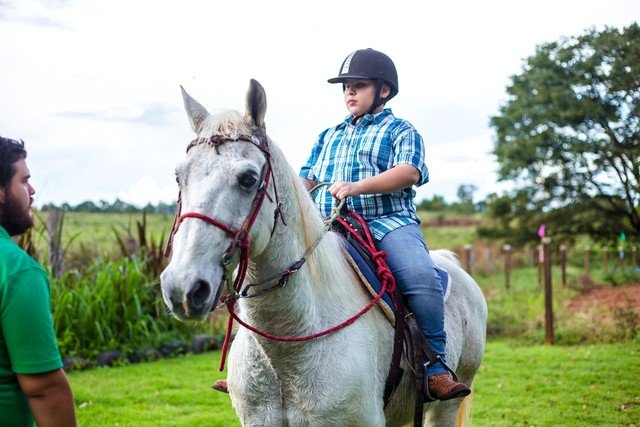 Descrição da imagem #PraCegoVer: Imagem no formato retangular, na horizontal. O menino Gabriel está montado no cavalo Pé de Pano. Fim da descrição;