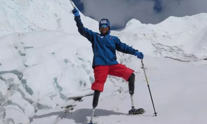 Descrição da imagem #PraCegoVer: Imagem no formato retangular, na horizontal. O chinês Xia Boyu,durante sua escalada ao Everest. Ele, que é biamputado, está em meio à neve. É possível ver suas próteses. Fim da descrição.