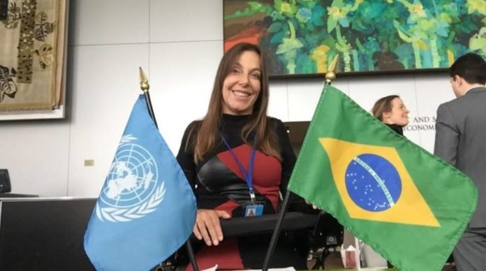 Descrição da imagem #PraCegoVer: Imagem no formato retangular na horizontal. A deputada Mara Gabrilli está em sua cadeira de rodas. À sua frente, vemos duas banheiras, uma do Brasil e outra da ONU. Mara está sorrindo. Fim da descrição.