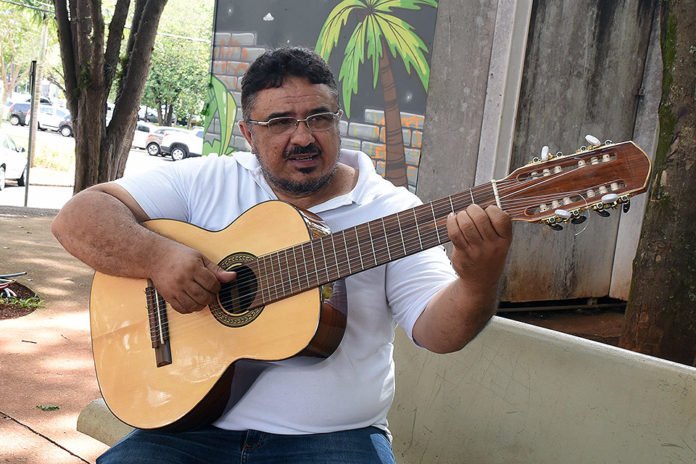 Descrição da imagem #PraCegoVer: Imagem no formato retangular, na horizontal. O músico Reinaldo Casteluzzo, tocando o violão terapêutico. Fim da descrição.