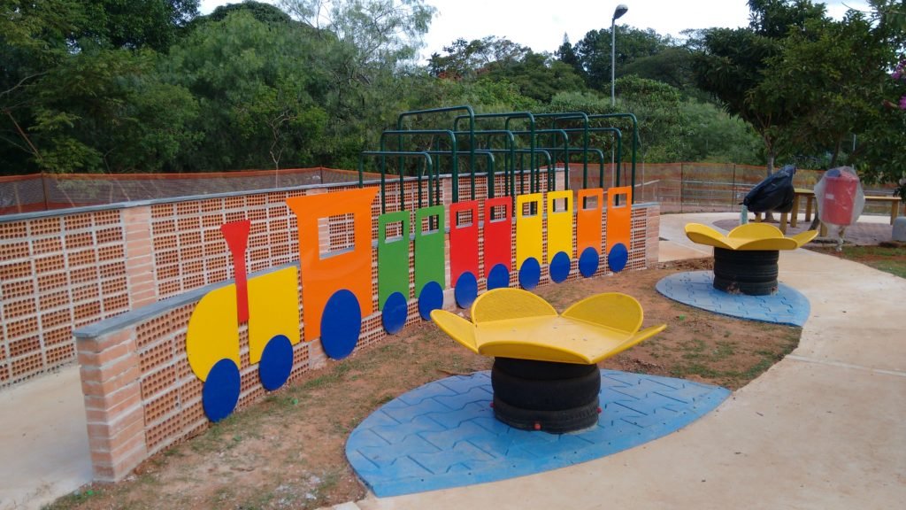 Descrição da imagem #PraCegoVer: Imagem no formato retangular, na horizontal. Área colorida, com brinquedo adaptado, no Parque do Cordeiro, que participa do projeto Anna Laura Parque Para Todos. Fim da descrição.