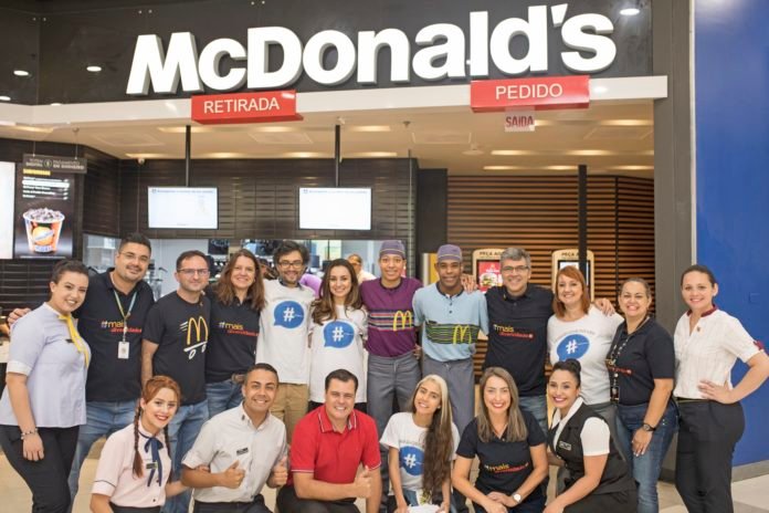 Descrição da imagem #PraCegoVer: Imagem no formato retangular, na horizontal. Grupo de pessoas que participaram da ação no McDonald's. Eles estão na frente da loja onde aconteceu a ação. Fim da descrição.
