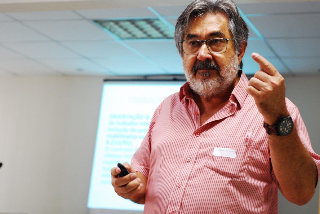 Descrição da imagem #PraCegoVer: Imagem no formato retangular, na horizontal. O coordenador do projeto de Inclusão da Pessoa com Deficiência em São Paulo, José Carlos do Carmo, o Kal. Ele é um homem moreno, de pele clara. Tem cabelos e barba grisalhos. Kal usa uma camisa rosa e está palestrando durante o evento. Fim da descrição.