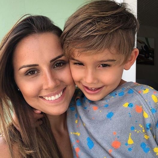 Descrição da imagem #PraCegoVer: Imagem no formato quadrado. Laryssa com o filho Pedro. Ela é uma mulher jovem, de cabelos castanhos, lisos e compridos. Pedro é loiro e tem a pele branca. Eles estão abraçados. Fim da descrição.