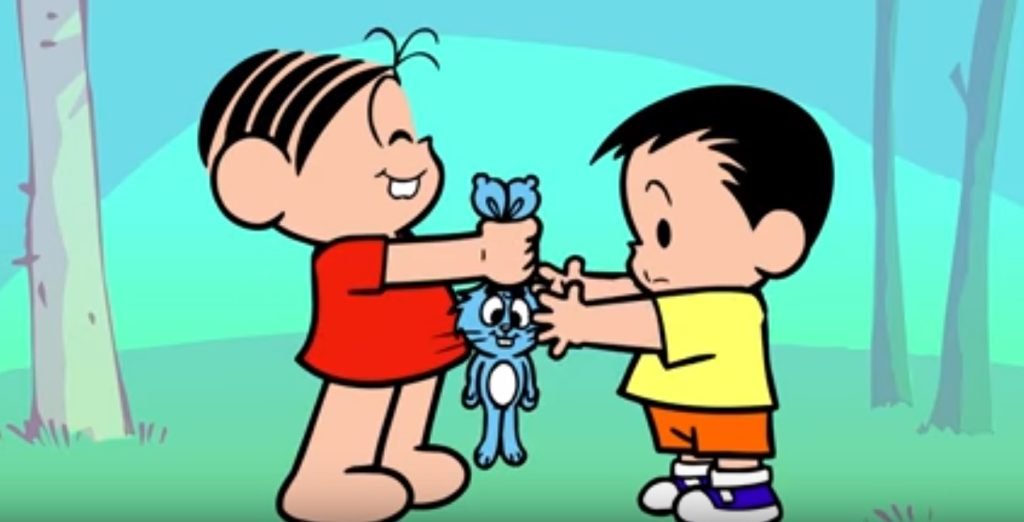 Descrição da imagem #PraCegoVer: Imagem no formato retangular, na horizontal. Mônica e André, personagem que tem autismo. Eles estão frente a frente, e Mônica está dando o coelho Sansão ao menino. Fim da descrição.