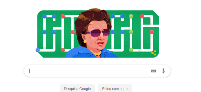 Descrição da imagem #PraCegoVer: Imagem no formato retangular na horizontal. A ilustração da dona Dorina Nowill. A imagem tem, ao fundo, que é da cor verde, a palavra Google, em letras brancas, escrita também em braile. Dorina é uma senhora morena, de pele clara, que tem os cabelos castanhos, curtos. Ela está usando óculos escuros, uma camisa azul e colares e brincos amarelos. Fim da descrição.
