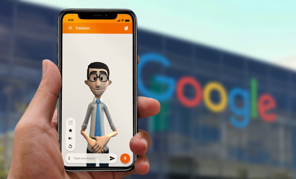 Descrição da imagem: #PraCegoVer Imagem no formato retangular, na horizontal. Um celular sendo segurado pela mão de um homem branco. Na tela, o aplicativo da Hand Talk aparece aberto. Atrás da mão e do celular há um prédio do Google. Fim da descrição.