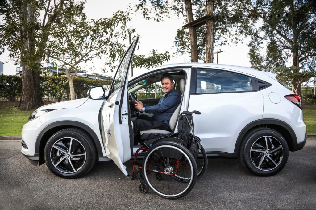 Descrição da imagem #PraCegoVer: Robson Jeronimo está sentado no banco do motorista do modelo Honda HR-V. A porta está aberta e sua cadeira de rodas está ao lado da porta. Fim da descrição.