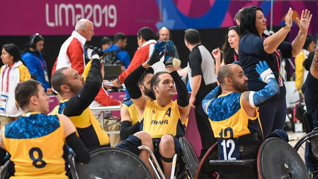 Descrição da imagem #PraCegoVer: Os paratletas de rugby em cadeira de rodas estão comemorando a primeira vitória no Parapan. Fim da descrição.
