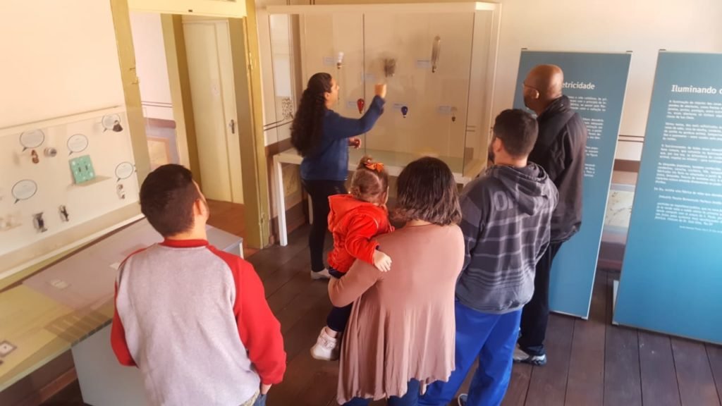 Descrição da imagem #PraCegoVer: Um grupo de pessoas está no Museu da Energia de Itu e acompanham uma visita em libras. Fim da descrição.