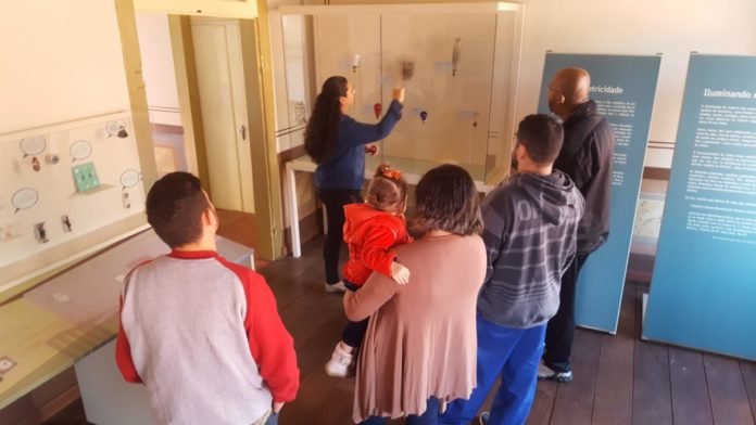 Descrição da imagem #PraCegoVer: Um grupo de pessoas está no Museu da Energia de Itu e acompanham uma visita em libras. Fim da descrição.