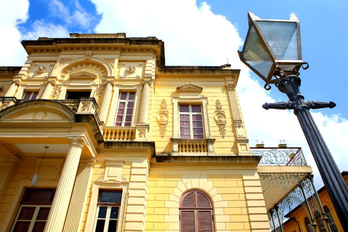 Descrição da imagem #PraCegoVer: Fachada do Museu da Energia de São Paulo. Um casarão bege, construído no final do século 19. Ao fundo vemos o céu azul. Fim da descrição.