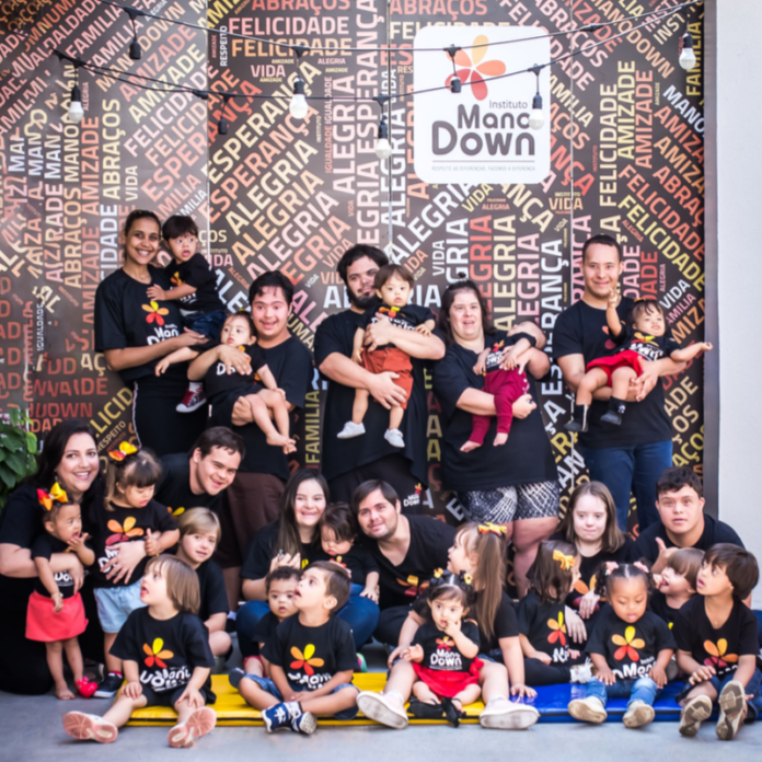 Descrição da imagem #PraCegoVer: Imagem de capa da agenda 2020 do Instituto Mano Down. Várias pessoas com e sem síndrome de Down estão reunidas e sorriem. Na parte superior da imagem está o logo do Instituto Mano Down. Fim da descrição.