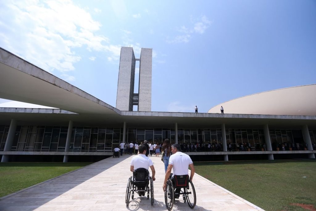 Descrição da imagem #PraCegoVer: Dois homens, cadeirantes, estão subindo a rampa do palácio do planalto, em Brasília. Fim da descrição.