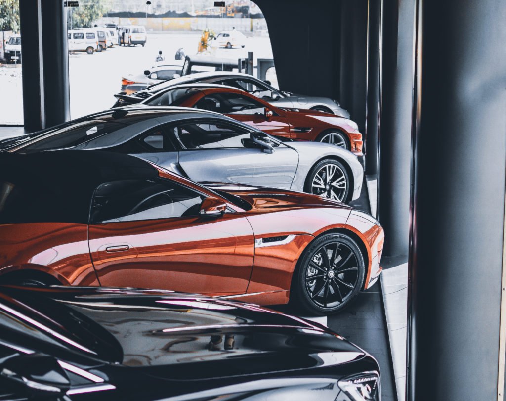 Descrição da Imagem #PraCegoVer: Uma loja de carros. Vários modelos de diferentes cores estão estacionados lado a lado. Fim da descrição.