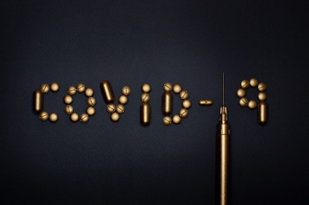 Descrição da imagem #PraCegoVer: A palavra Covid-19 está escrita com peças de metal. A palavra está sobre uma superfície preta. Fim da descrição.