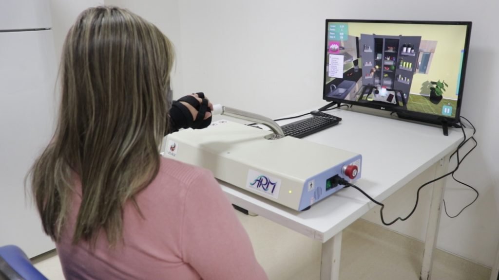 Descrição da imagem #pratodosverem: Uma mulher está realizando uma terapia em um equipamento. Fim da descrição.