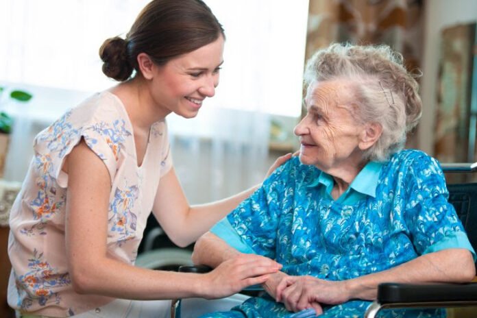 Descrição da imagem #pracegover: Foto de uma mulher e uma idosa. Elas estão sentadas lado a lado e sorriem. Fim da descrição.