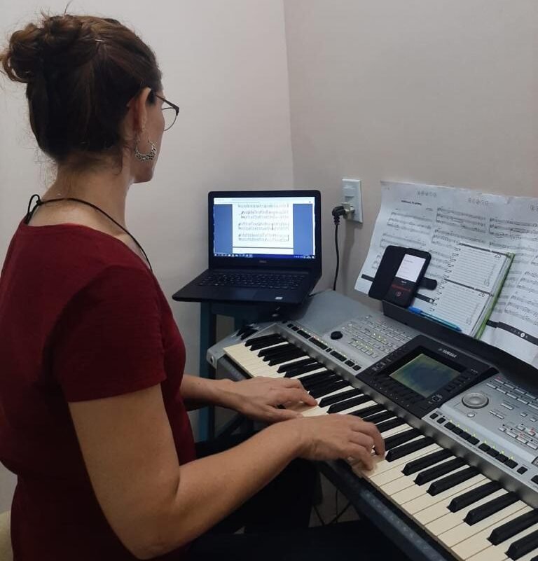 Descrição da imagem #pracegover: Teresa Criscuolo durante o trabalho. Ela está sentada, tocando teclado e olhando a tela do computador. Teresa está de costas. Ela é morena e tem cabelos compridos castanhos, que estão presos em um coque. Fim da descrição.