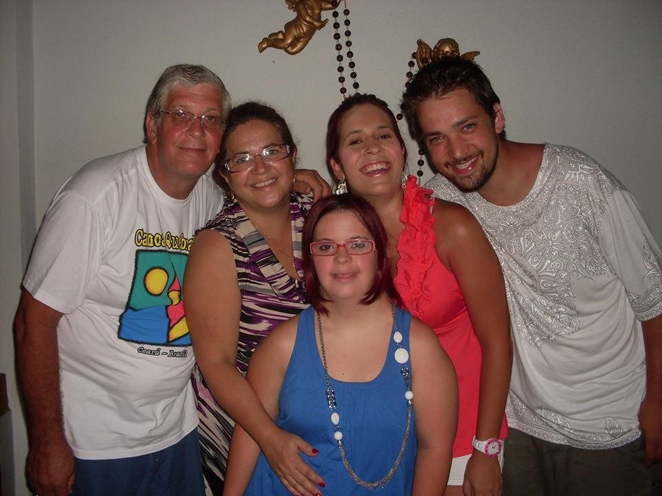 Descrição da imagem #pracegover: Foto da família de Tomás André. Nela estão Tomás com a esposa Célia e os três filhos. Entre eles, duas moças, uma delas com Down, e um rapaz. Eles estão sorrindo. Fim da descrição.