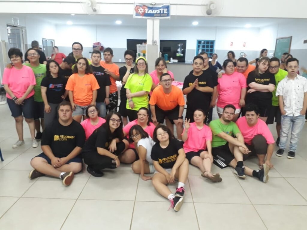 Descrição da imagem #pracegover: Foto do grupo de jovens com síndrome de Down durante encontro do Felicidade Down. Eles estão usando camisetas coloridas. Fim da descrição.