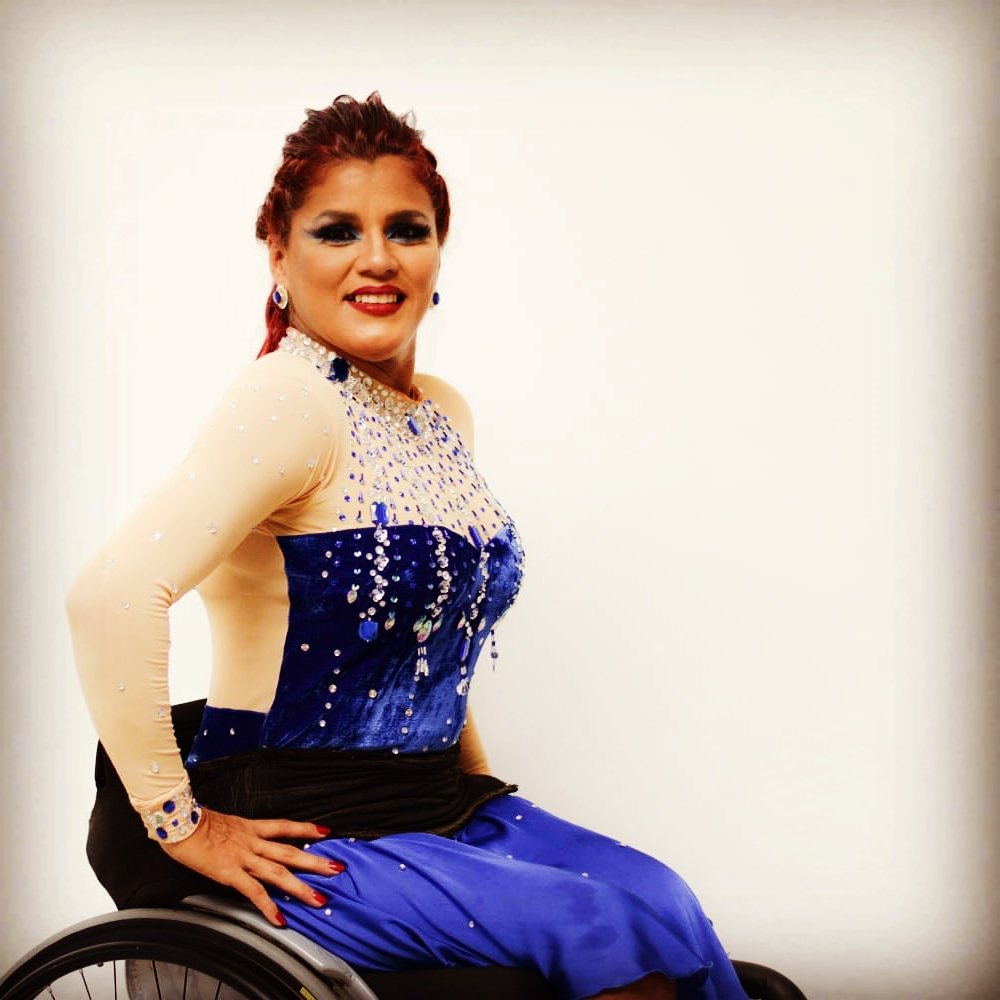 Descrição da imagem #pracegover: A bailarina Aída durante ensaio. Ela está em sua cadeira de rodas. Aída é uma mulher morena, de cabelos castanhos, que estão presos em um rabo de cavalo. Fim da descrição.
