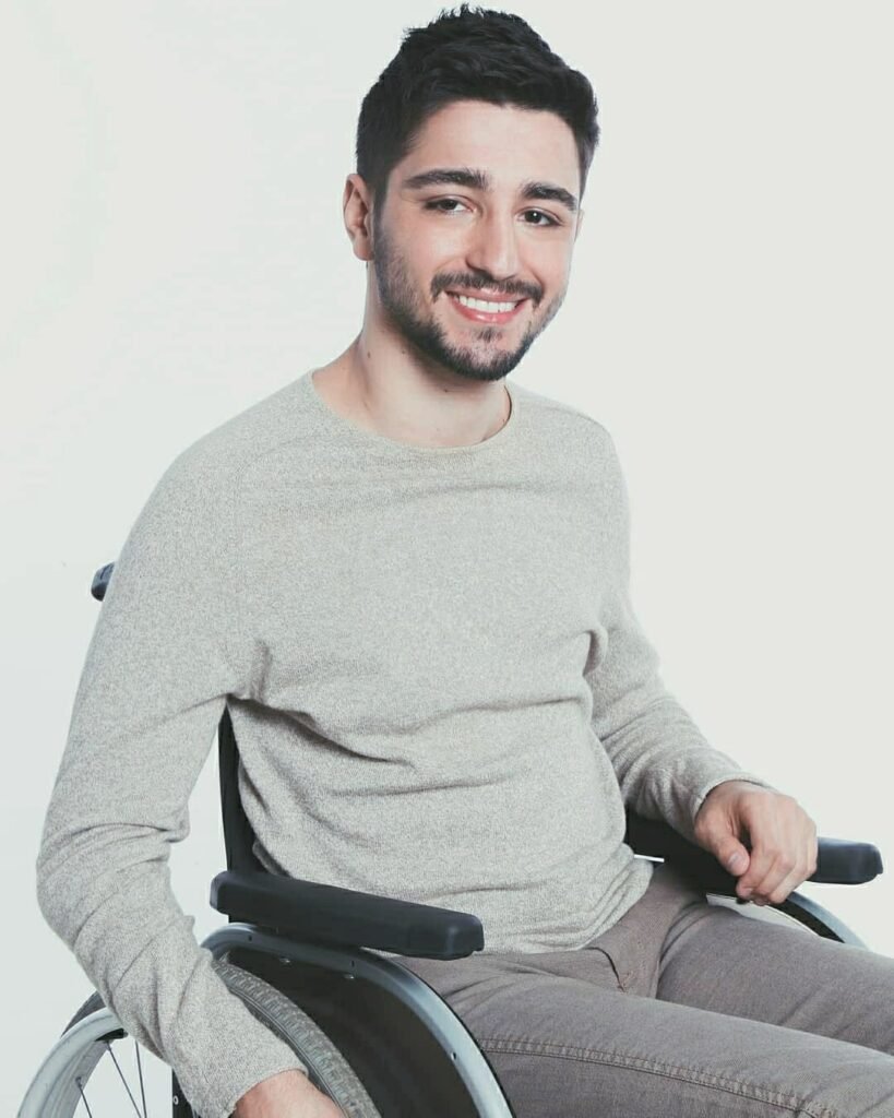 Descrição da imagem #pracegover: Foto de André Venturini. Ele é um homem moreno, de cabelos curtos e castanhos. André está vestindo uma blusa cinza de mangas compridas e está em sua cadeira de rodas. Fim da descrição.