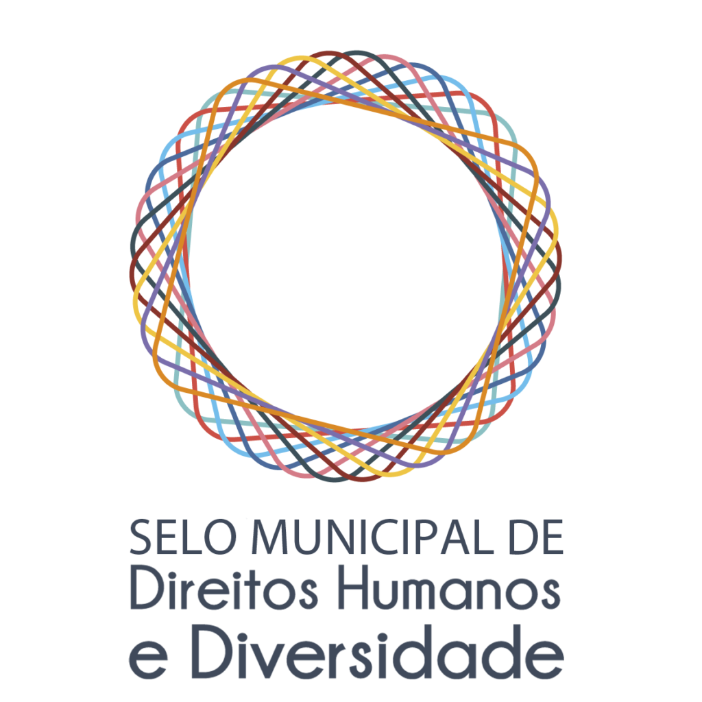 Descrição da imagem #pracegover: Arte de divulgação do Selo Municipal de Direitos Humanos e Diversidade. Ele é formado pela imagem de um círculo composto por linhas coloridas entrelaçadas.Fim da descrição.