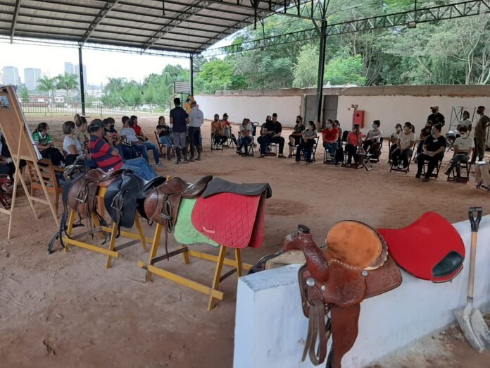 Descrição da imagem #pracegover: Os participantes do curso de equoterapia durante uma atividade, realizada no setting terapêutico da Hípica Santa Terezinha. Fim da descrição.