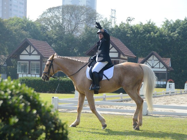 Descrição da imagem #pracegover: Foto do cavaleiro Claudio Aleoni Arruda. Ele está montando o cavalo e acena. Fim da descrição.