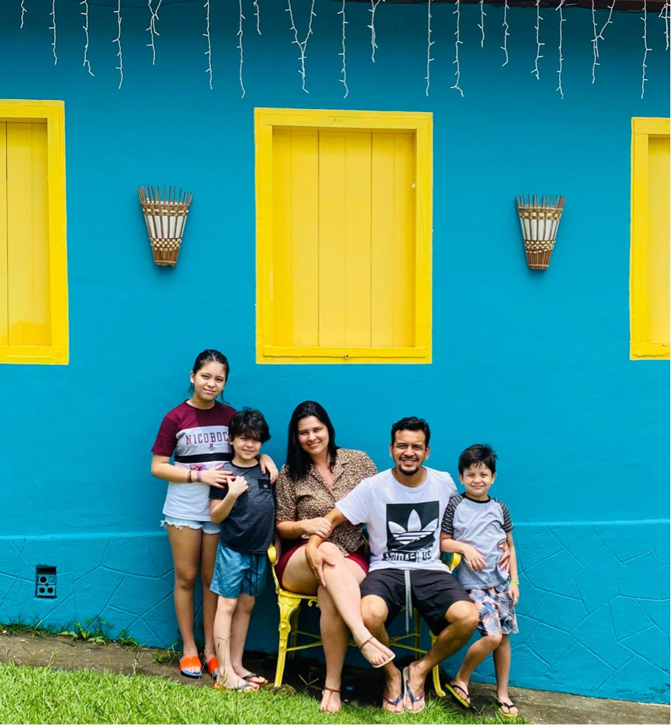 Descrição da imagem #pracegover: Foto de uma família. Pai e mãe estão com três filhos. Fim da descrição.
