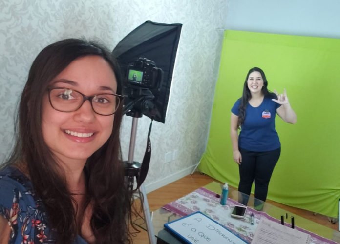 Descrição da imagem: Foto de Cassia com a amiga Fernanda durante as gravações das traduções para o Mundo Bita. Elas estão em um estúdio. Fim da descrição.