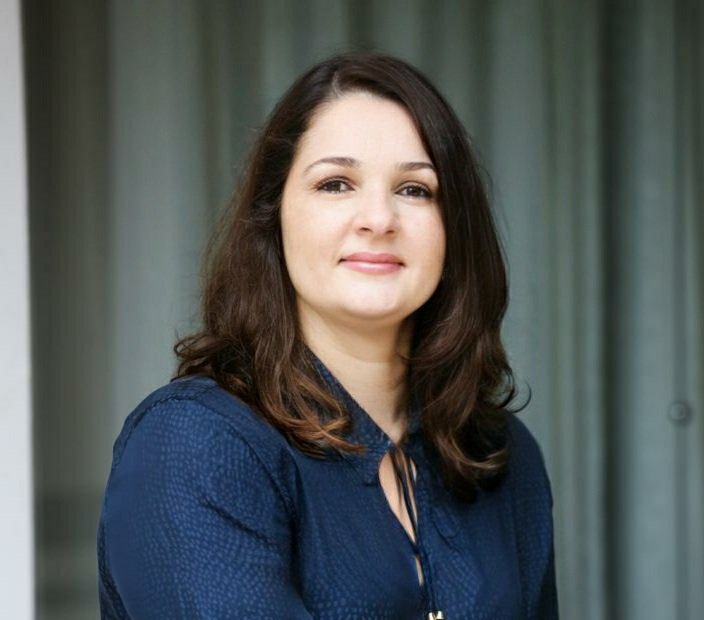 Descrição da imagem: Foto de close da psicóloga Luciana Deutscher. Ela é uma mulher branca, de cabelos castanhos, lisos, abaixo da altura dos ombros. Fim da descrição.